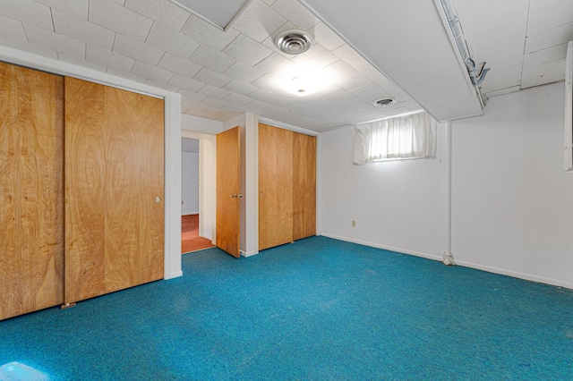 below grade area with baseboards, visible vents, and carpet floors