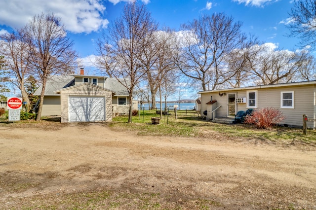 view of yard with fence, dirt driveway, and a garage