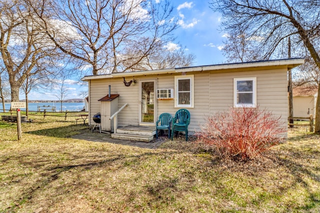 exterior space with a lawn, a water view, and fence