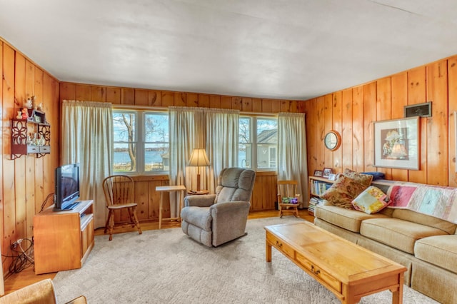 living room featuring light colored carpet and wood walls