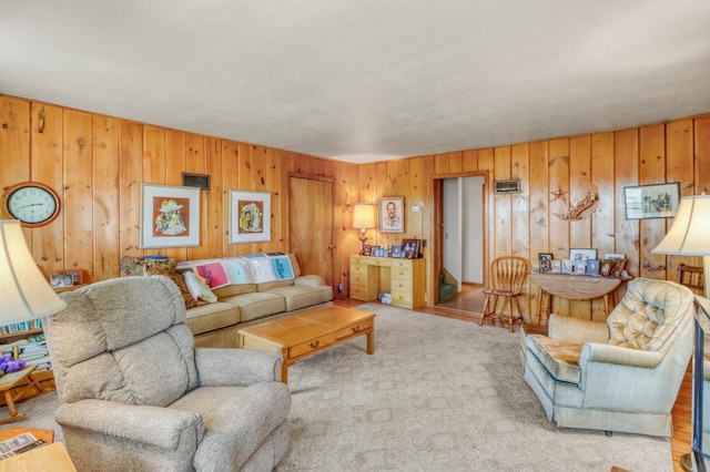 carpeted living room featuring wood walls