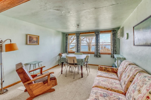 carpeted dining area featuring baseboards, a wall mounted AC, and a textured ceiling