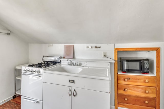 kitchen with black microwave, light countertops, dark wood finished floors, white cabinetry, and white gas stove