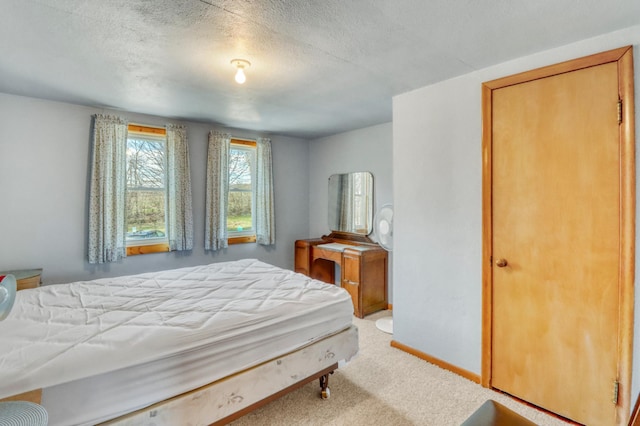 carpeted bedroom featuring baseboards and a textured ceiling