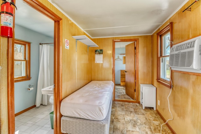 bedroom with wooden walls, baseboards, and a wall mounted air conditioner
