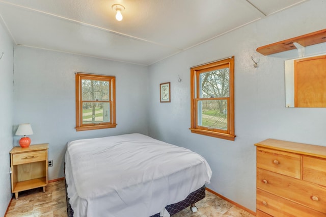 bedroom with baseboards and multiple windows