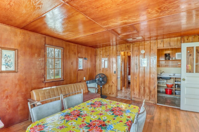 dining room with hardwood / wood-style floors, wooden walls, and wooden ceiling
