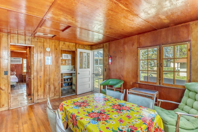 bedroom featuring wooden walls, multiple windows, wooden ceiling, and wood-type flooring