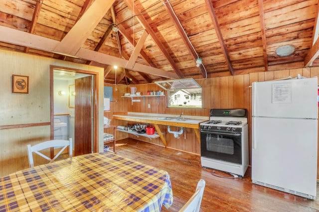 kitchen featuring range with gas stovetop, freestanding refrigerator, wood walls, wooden ceiling, and light wood-style flooring