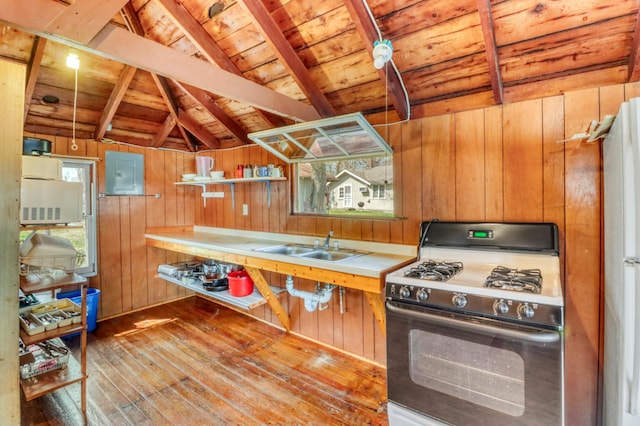 kitchen featuring wood-type flooring, wooden walls, vaulted ceiling with beams, wood ceiling, and gas stove