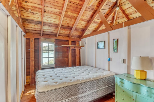 bedroom featuring lofted ceiling with beams, wood ceiling, and wood finished floors
