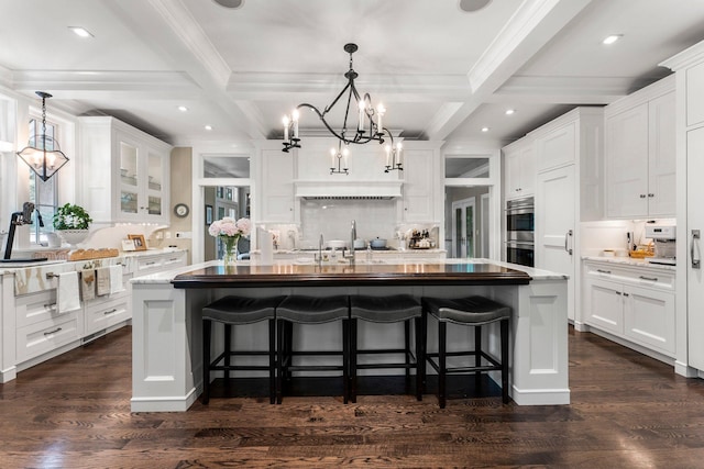 6601 Blackfoot Pass, Edina, MN 55439 - kitchen featuring white cabinetry, a notable chandelier, an island with sink, and beamed ceiling