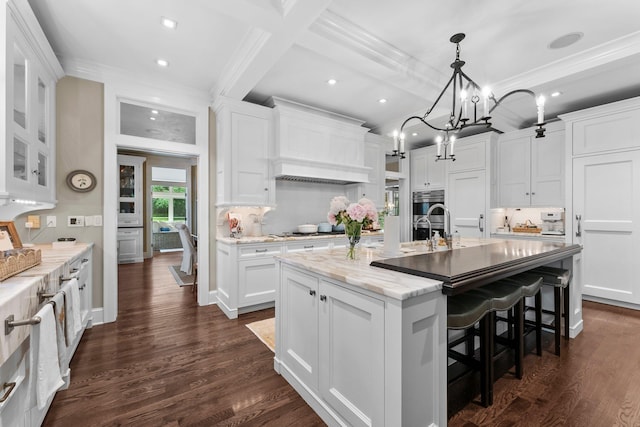 6601 Blackfoot Pass, Edina, MN 55439 - kitchen featuring a kitchen island with sink, dark wood-style flooring, white cabinets, and crown molding