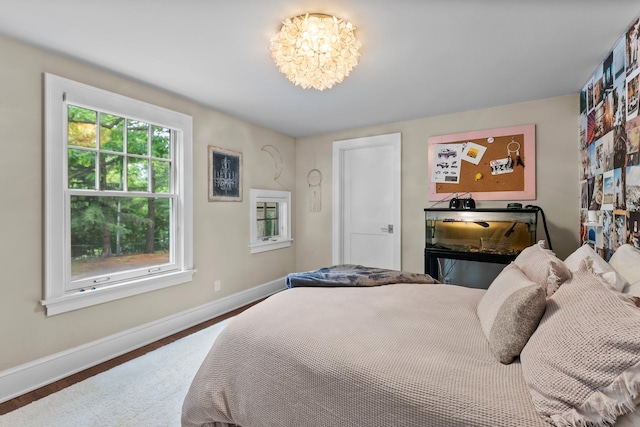 6601 Blackfoot Pass, Edina, MN 55439 - bedroom featuring baseboards, a chandelier, and wood finished floors