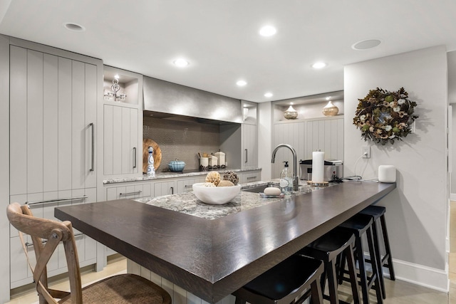 6601 Blackfoot Pass, Edina, MN 55439 - kitchen featuring a breakfast bar area, recessed lighting, dark stone counters, a sink, and white cabinets