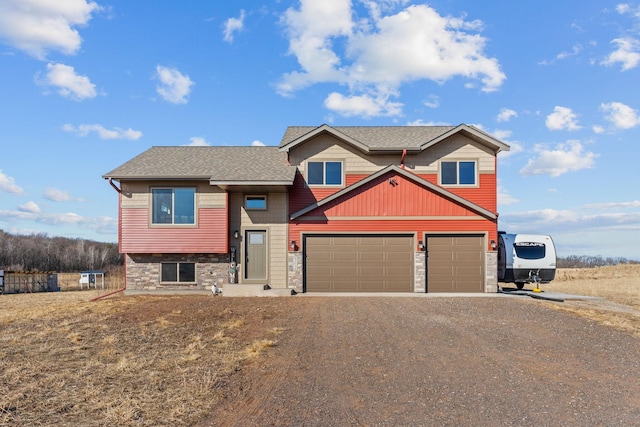 view of front of house featuring driveway, stone siding, a garage, and roof with shingles
