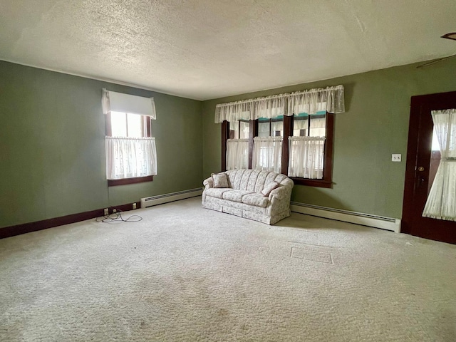 unfurnished living room with carpet floors, a textured ceiling, and baseboard heating