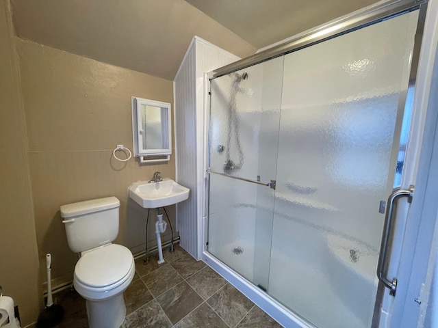full bath featuring toilet, a sink, and a shower stall