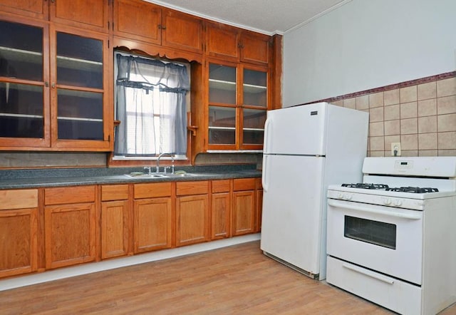 665 Bedford St, Saint Paul, MN 55130 - kitchen featuring white appliances, brown cabinetry, glass insert cabinets, light wood-style flooring, and dark countertops
