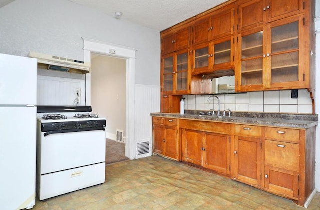 665 Bedford St, Saint Paul, MN 55130 - kitchen featuring white appliances, extractor fan, brown cabinets, glass insert cabinets, and dark countertops