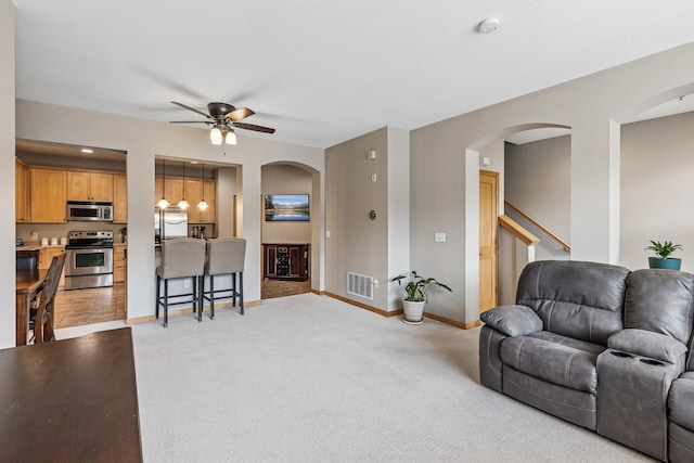 294 Spring St, Saint Paul, MN 55102 - living room with arched walkways, ceiling fan, light colored carpet, recessed lighting, and stairs
