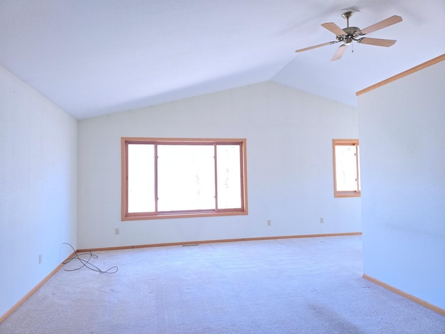 empty room with baseboards, ceiling fan, light carpet, and vaulted ceiling