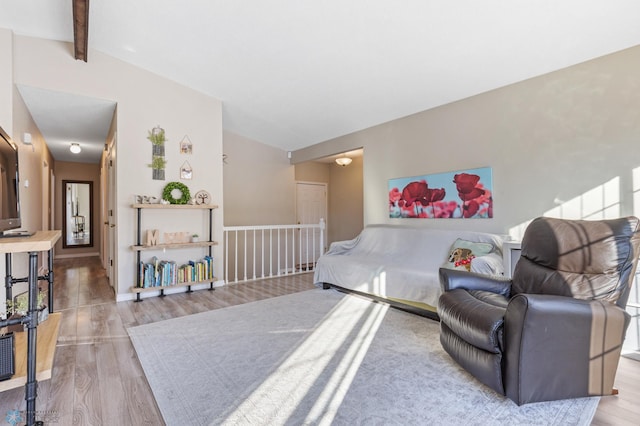 bedroom featuring lofted ceiling with beams and wood finished floors