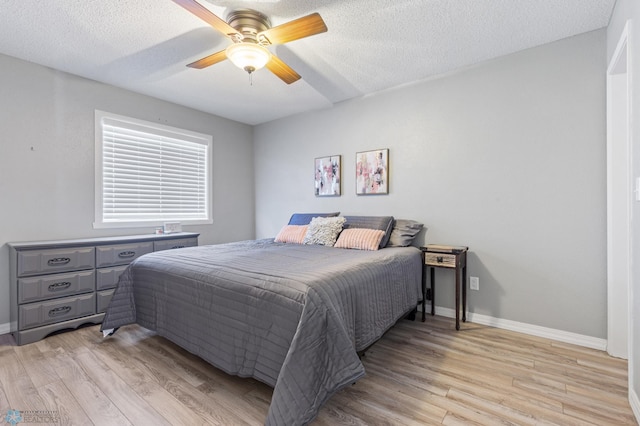 bedroom featuring a textured ceiling, baseboards, and light wood-type flooring