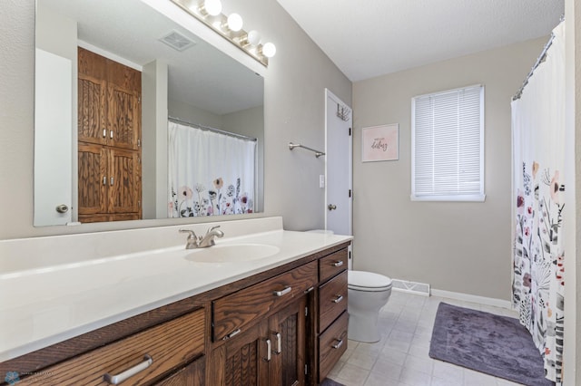 bathroom with toilet, vanity, baseboards, and visible vents