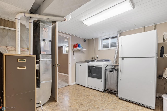 laundry area featuring heating unit, light tile patterned floors, washer and clothes dryer, and laundry area
