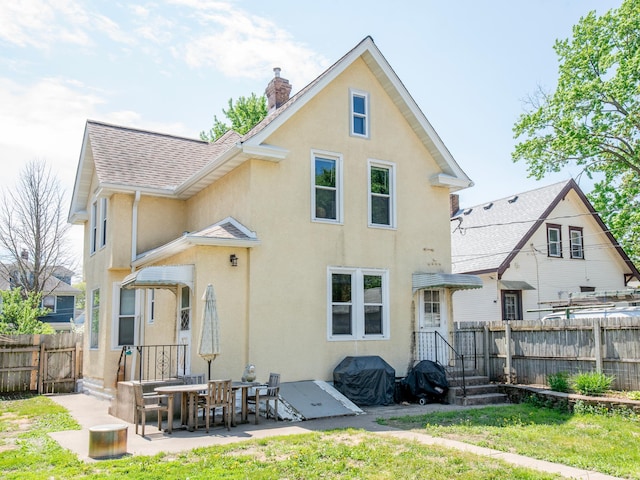 115 Geranium Ave W, Saint Paul, MN 55117 - rear view of property with a fenced backyard, stucco siding, a chimney, and a patio