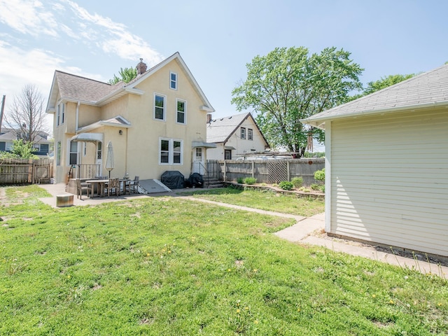 115 Geranium Ave W, Saint Paul, MN 55117 - rear view of house with a fenced backyard, a patio area, stucco siding, and a chimney