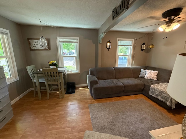 328 Jefferson Pl, Faribault, MN 55021 - living room with light wood-style floors, ceiling fan, a textured ceiling, and baseboards