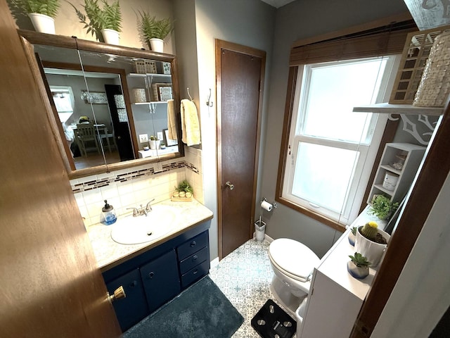 328 Jefferson Pl, Faribault, MN 55021 - bathroom featuring toilet, vanity, tasteful backsplash, and baseboards
