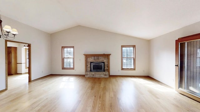 unfurnished living room featuring light wood-style flooring, a notable chandelier, a healthy amount of sunlight, and lofted ceiling