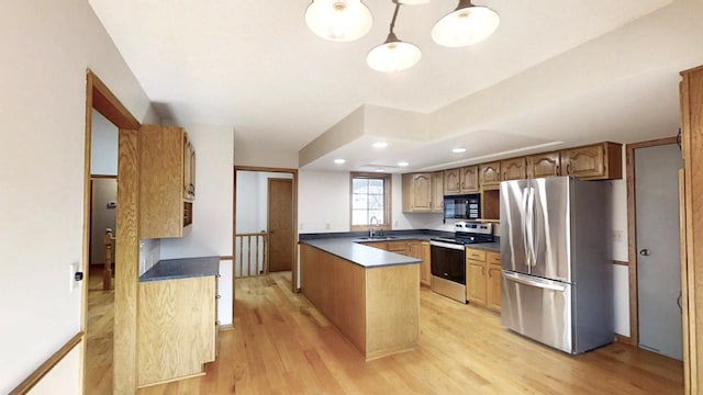 kitchen featuring a sink, stainless steel appliances, light wood-style floors, and dark countertops