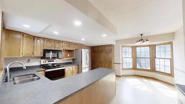 kitchen featuring a sink, appliances with stainless steel finishes, a peninsula, baseboards, and recessed lighting