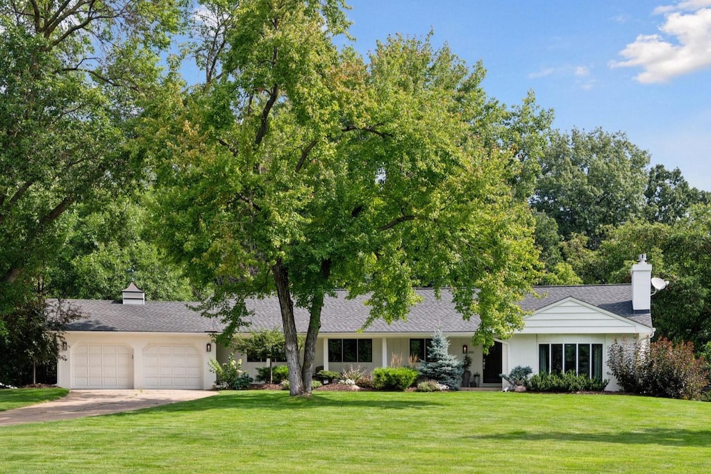 6621 Sally Ln, Edina, MN 55439 - ranch-style house with stucco siding, an attached garage, concrete driveway, and a front yard