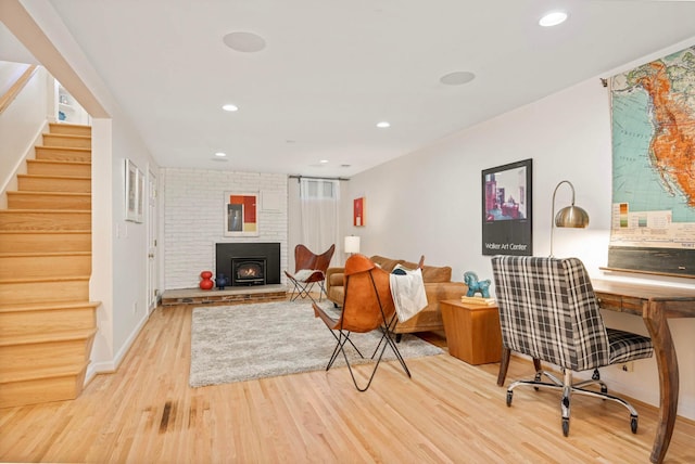 living room with recessed lighting, baseboards, stairs, light wood-style floors, and a fireplace