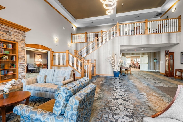 living area featuring baseboards, a towering ceiling, stairway, and a raised ceiling