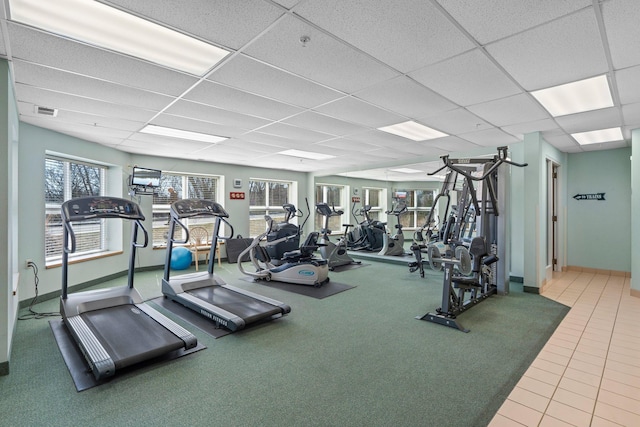 workout area featuring a drop ceiling, tile patterned floors, baseboards, and visible vents