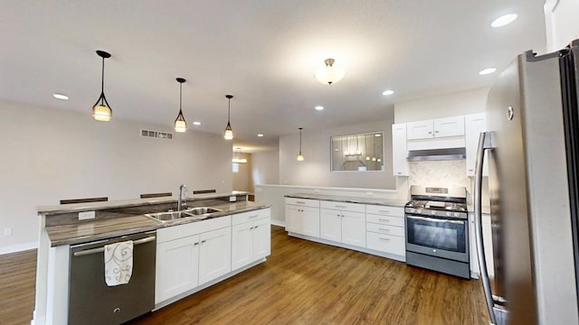 kitchen with dark wood-style flooring, stainless steel appliances, a sink, visible vents, and white cabinets