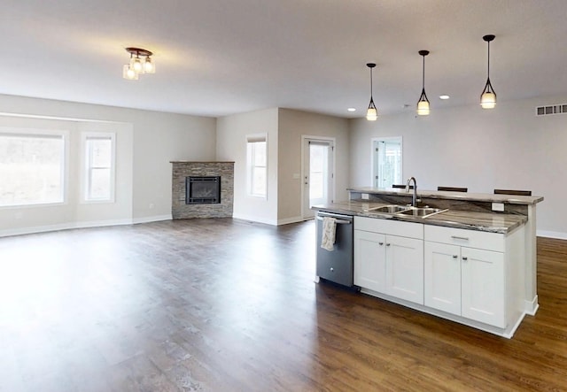 kitchen with dark wood-style flooring, visible vents, dishwasher, a fireplace, and a sink