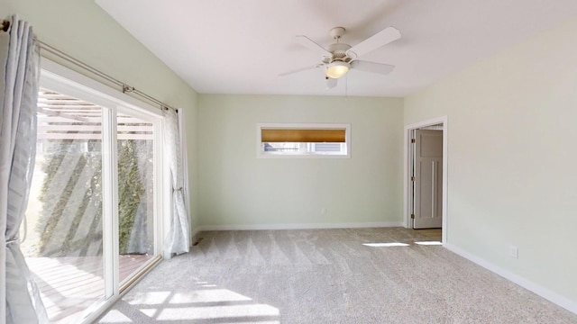 carpeted spare room featuring a ceiling fan and baseboards