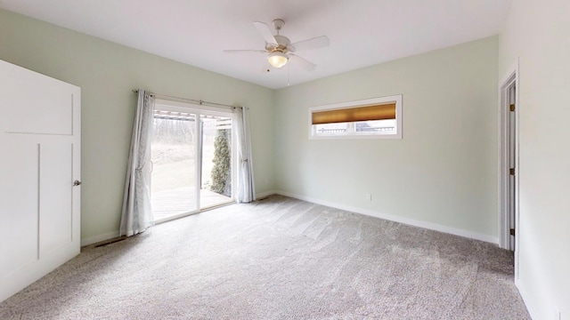 carpeted spare room featuring baseboards and a ceiling fan