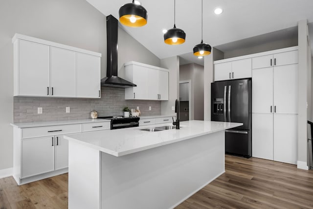 kitchen featuring wall chimney exhaust hood, black appliances, a sink, decorative backsplash, and vaulted ceiling