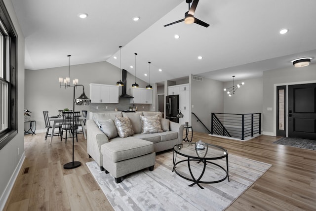 living room featuring a chandelier, light wood finished floors, baseboards, recessed lighting, and ceiling fan