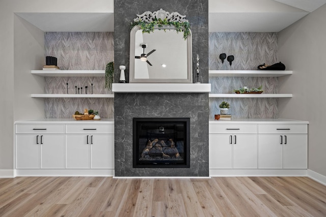 unfurnished living room featuring light wood-style flooring, baseboards, and a tile fireplace