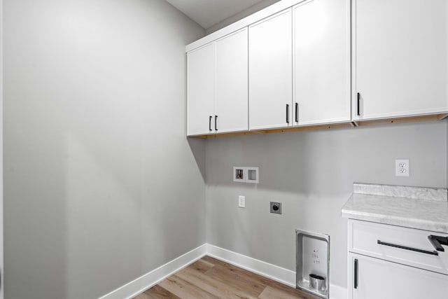 washroom featuring cabinet space, electric dryer hookup, washer hookup, baseboards, and light wood-type flooring