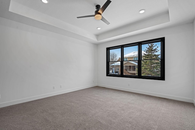 unfurnished room with a tray ceiling, a ceiling fan, baseboards, carpet, and recessed lighting